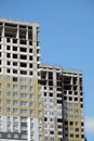 Process of mounting insulation on apartment building facade in new modern urban house over blue sky with clouds front view Royalty Free Stock Photo