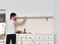 Mounting shelves on the wall. All necessary tools are placed on the chest of drawers