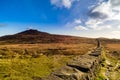 Mourn Wall on the bank of Slieve Donard mountain with blue sky, white clouds and sunlight