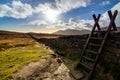 Mourn Wall with ladder on the bank of Slieve Donard mountain with blue sky, white clouds and sunrays