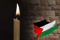 mourning candle burning front of flag Palestine, memory of heroes served country, grief over loss, national unity in challenging