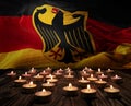 Mourning candles burning on Federal Republic of Germany flag background. Memorial weekend, patriot veterans day, National Day of