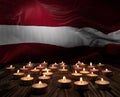 Mourning candles burning on Latvia national flag of background. Memorial weekend, patriot veterans day, National Day of Service