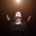 Mourning woman praying, with arms outstretched in worship to god