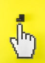 the mouse cursor hand points to the black enter button from the keyboard. yellow background