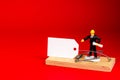 A mousetrap with a white paper sign and a boss figurine on a red background. Illegal employment, abuse of office