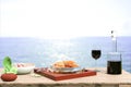 Moussaka dish accompanied by red wine from the island of crete, greek salad and fresh mint leaves on a defocused sea Royalty Free Stock Photo