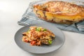 Moussaka, Greek casserole of eggplants, potatoes, minced meat and tomatoes, served on a blue gray plate with parsley garnish on a Royalty Free Stock Photo