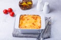 Moussaka with meat, eggplant, tomatoes, potatoes, bechamel sauce and cheese on a white plate. Traditional Greek dish. Close-up Royalty Free Stock Photo