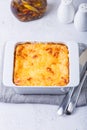 Moussaka with meat, eggplant, tomatoes, potatoes, bechamel sauce and cheese on a white plate. Traditional Greek dish. Close-up Royalty Free Stock Photo