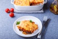 Moussaka with meat, eggplant, tomatoes, potatoes, bechamel sauce and cheese on a white plate. Traditional Greek dish. Close-up Royalty Free Stock Photo