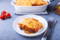 Moussaka with meat, eggplant, tomatoes, potatoes, bechamel sauce and cheese on a white plate. Traditional Greek dish. Close-up Royalty Free Stock Photo