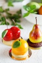 Mousse dessert in the shape of a pear fruit, orange fruit and cherry Royalty Free Stock Photo