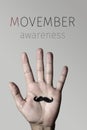 Moustache in a hand and text movember