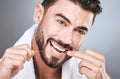 Mouth floss, tooth and man in studio for wellness, healthy body care or hygiene on background. Teeth, flossing and guy Royalty Free Stock Photo