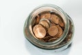 Mouth of a glass jar full of coins on white background Royalty Free Stock Photo