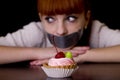 Mouth sealed with tape sad looking at cakes Royalty Free Stock Photo