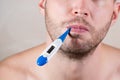 Mouth of an unshaven man holding an electronic thermometer in his mouth