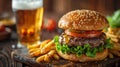 Delicious classic American burger with lager beer and fries on wooden table Royalty Free Stock Photo