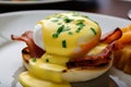mouth-watering close-up of Eggs Benedict with crispy bacon, fresh chives, and creamy hollandaise sauce drizzled on top of a