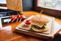 Served table in a rustic cafe with tomatoes and burger