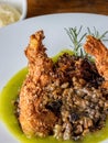 Mouth-watering plate of fried chicken served with a vibrant green sauce and mushrooms