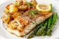 A mouth-watering plate of grilled cod fillet, garnished with a lemon slice, accompanied by roasted potatoes Royalty Free Stock Photo