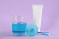 Mouthwash, toothbrush, paste and dental floss on violet background Royalty Free Stock Photo