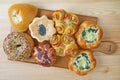 Assorted sweet and savory buns on wooden breadboard Royalty Free Stock Photo