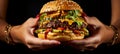 Mouthwatering burger held by hands, ready to eat perfect for advertising with ample copy space