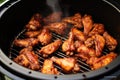 Mouthwatering chicken wings are being cooked to perfection on a grill, creating an irresistible aroma, Frying BBQ chicken wings in