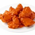 Chicken wings in tomato sauce isolated on white background. Selective focus. AI-Generated