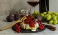 Oven baked Camembert, branch of green grapes, figs, honey, red currant, wine Royalty Free Stock Photo