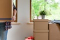 Move. Cardboard boxes for moving into a new, clean home. In a sunny day by a window in attic. Beautifull women holding boxes Royalty Free Stock Photo