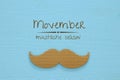 Movember cancer awareness event concept over wooden background. Top view
