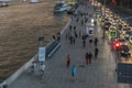 The movement of cars on the waterfront, strolling people and boats on the river, caught in an unexpected downpour