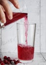 movement in the frame of water transfusion in another glass of Morse. shot on a light wooden background with cranberry berries.