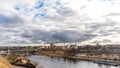 The movement of gray rain clouds over the river and a panorama of the city. View of the embankment along the river and the road Royalty Free Stock Photo