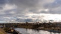 The movement of gray rain clouds over the river and a panorama of the city. View of the embankment along the river and the road Royalty Free Stock Photo
