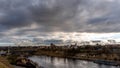 The movement of gray rain clouds over the river and a panorama of the city. View of the embankment along the river and the road Royalty Free Stock Photo
