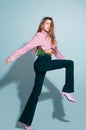 Movement model. Fashion woman in pink shirt and jeans. Pretty young lady in a fashion pose, full length. Royalty Free Stock Photo