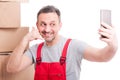 Mover guy making calling gesture taking selfie and smiling