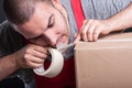 Mover guy ripping duct tape with teeth Royalty Free Stock Photo