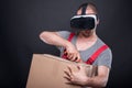 Mover guy wearing vr glasses using cutter on box Royalty Free Stock Photo