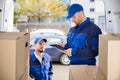 Mover Looking At His Partner Writing On Clipboard Royalty Free Stock Photo