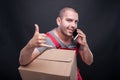 Mover man holding box making calling gesture Royalty Free Stock Photo