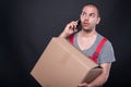 Mover man holding box talking on mobile phone Royalty Free Stock Photo