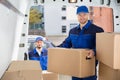 Mover Unloading Cardboard Box From Truck Royalty Free Stock Photo