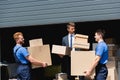 Movers with boxes standing near businessman