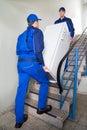 Movers Carrying Refrigerator On Steps At Home Royalty Free Stock Photo